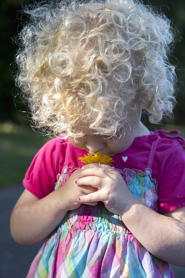 Portrait of young girl (4-5) smelling flower