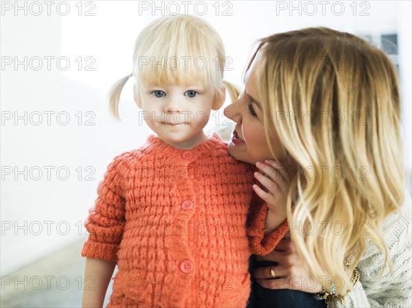 Cute girl (2-3) looking at camera with mother