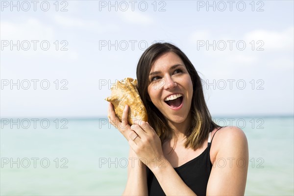 Woman listening to seashell