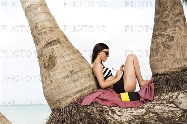 Woman relaxing by palm trees