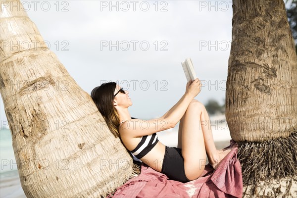 Woman relaxing by palm trees