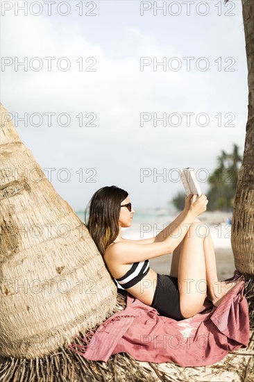 Woman relaxing by palm trees