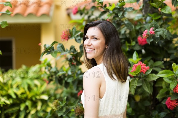 Portrait of woman against blooming bush