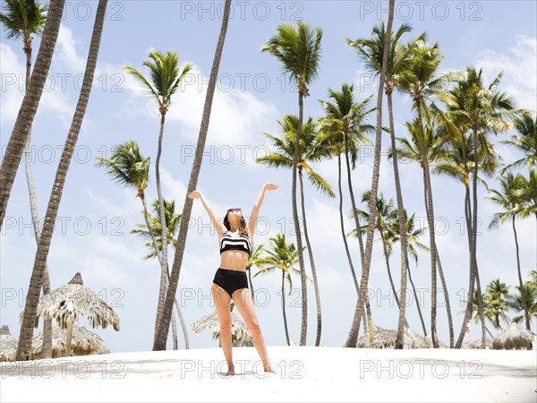 Woman on beach against palm trees