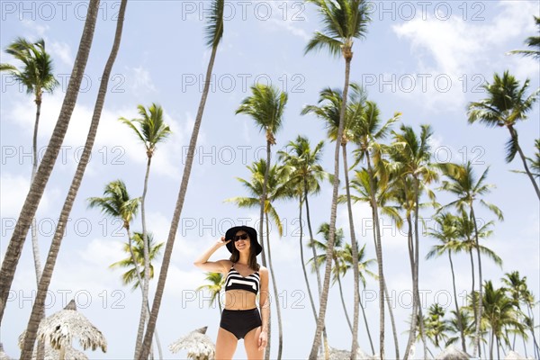Woman on beach against palm trees