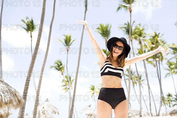 Woman on beach against palm trees