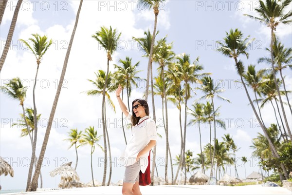 Woman standing beneath palm trees