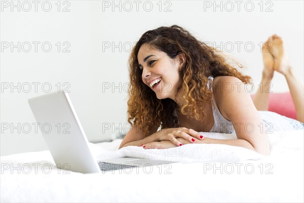 Woman using laptop in bed