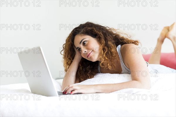 Woman using laptop in bed