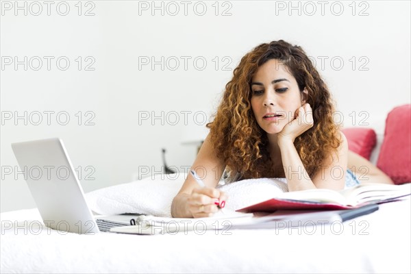 Woman with laptop in bed