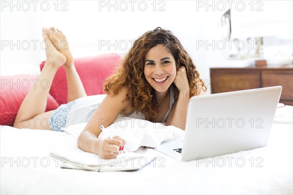 Woman with laptop in bed