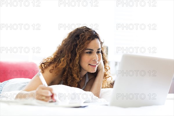 Woman with laptop in bed