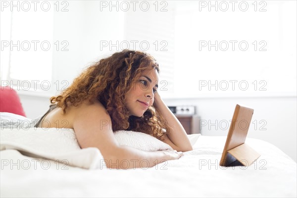 Woman with digital tablet in bed