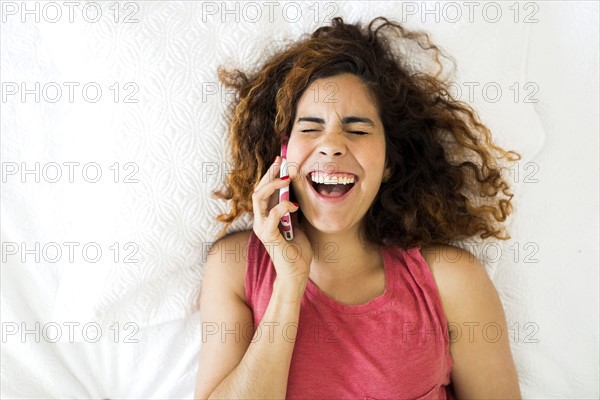 Woman using phone in bed