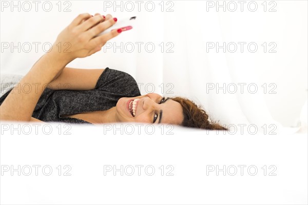 Woman using phone in bed