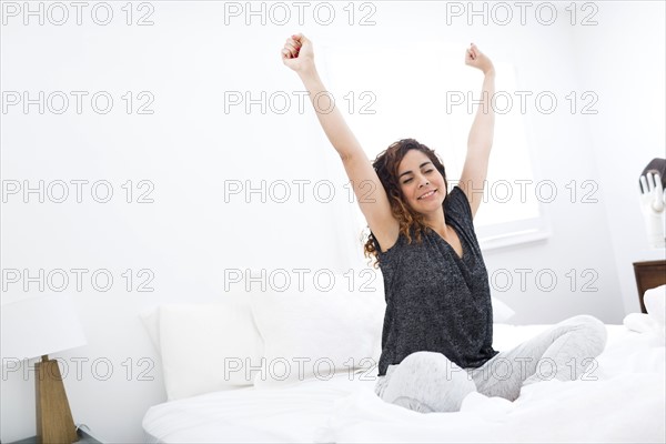 Woman stretching in bed