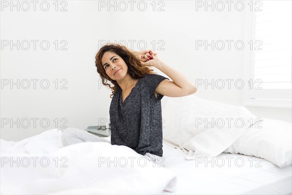 Woman stretching in bed