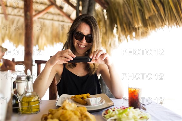 Woman by table, using phone