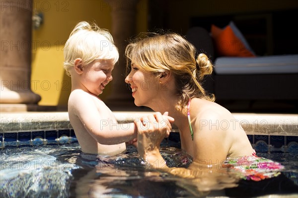 Mother with son (2-3) in swimming pool