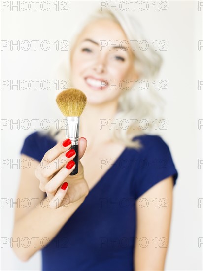 Studio shot of woman holding make-up brush