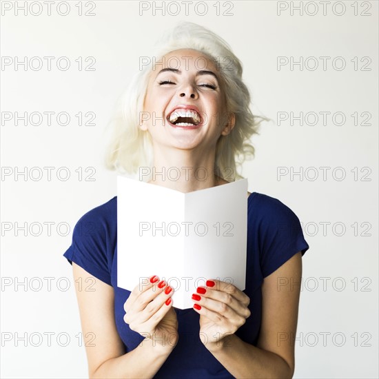 Studio shot of woman holding paper