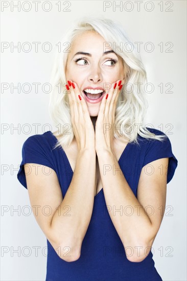 Studio shot of woman holding hands on cheeks