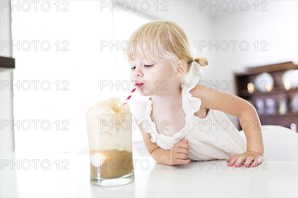 Girl (2-3) drinking milkshake