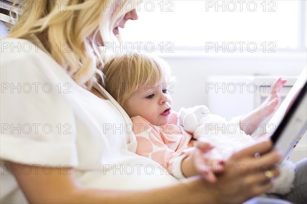 Mother reading book with daughter (2-3)