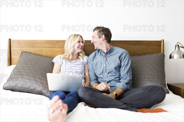 Couple sitting on bed