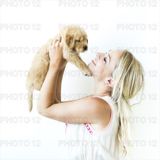 Studio shot of Golden Retriever puppy with owner