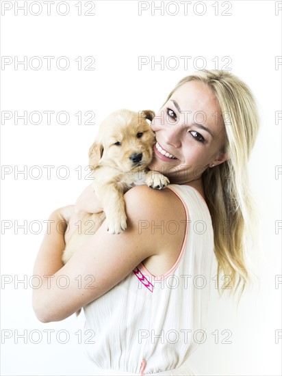 Studio shot of Golden Retriever puppy with owner