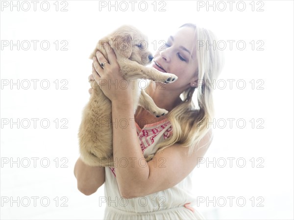 Studio shot of Golden Retriever puppy with owner