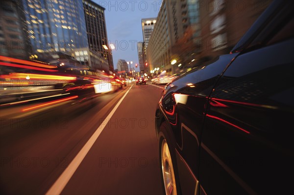 Car driving through city at dusk