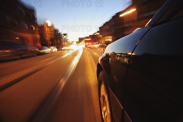 Car driving through city at dusk