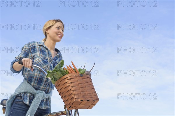 Portrait of young woman with bicycle.