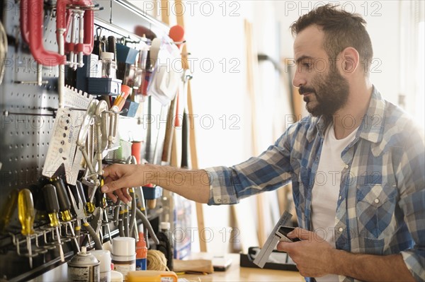 Man choosing tools in workshop.