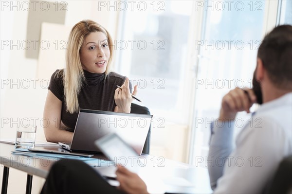 Man and woman talking in office.