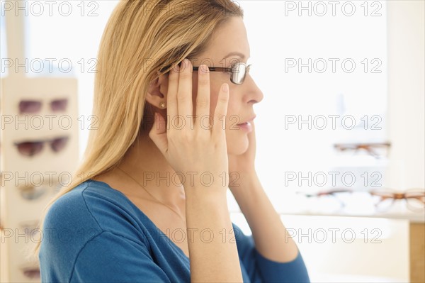 Woman trying on eyeglasses in store.