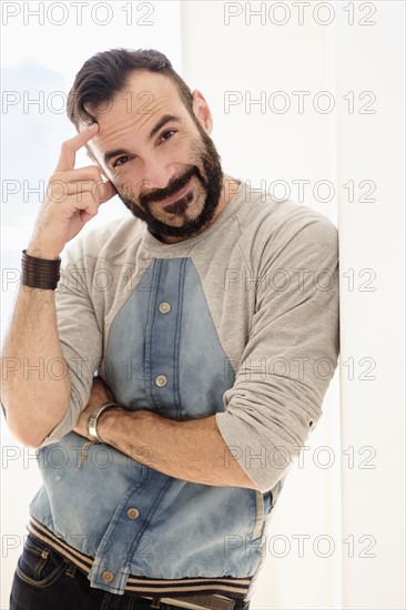 Portrait of man leaning on wall.