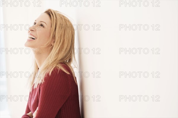 Portrait of young woman looking up and laughing.