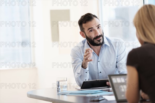 Man and woman talking in office.