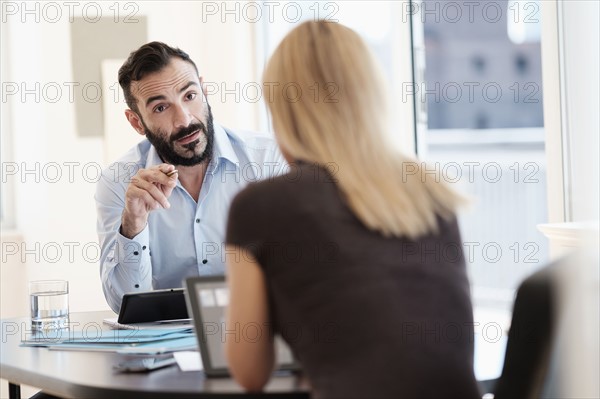 Man and woman talking in office.