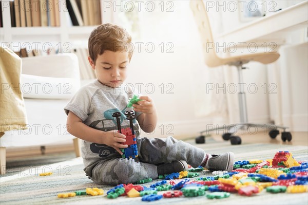 Boy (2-3) playing with toy blocks.