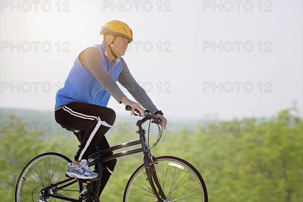 Mature man riding bicycle.