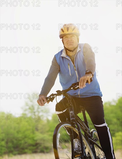 Mature man riding bicycle.