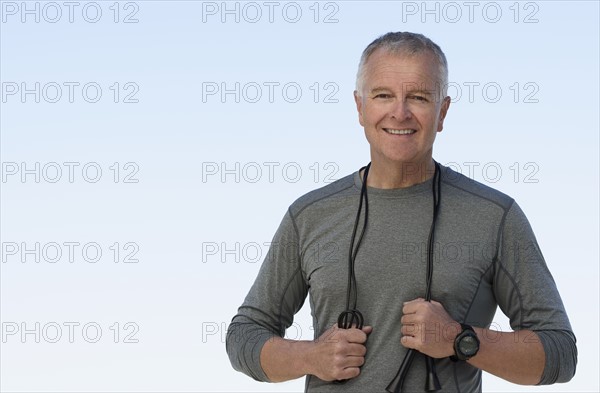 Man with jump rope against clear sky.