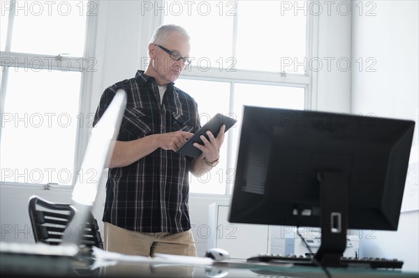 Man in office using digital tablet.