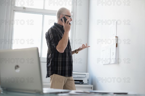 Man in office using smartphone.