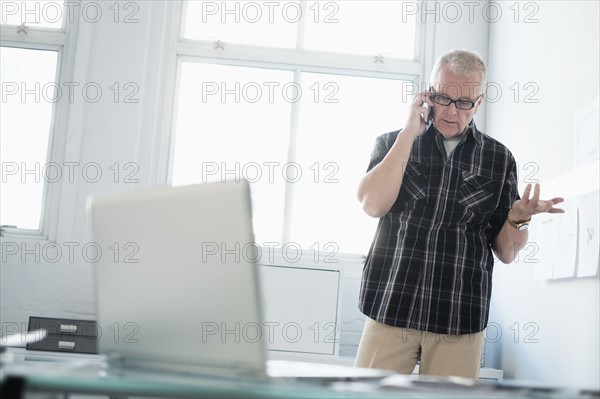 Man in office using smartphone.