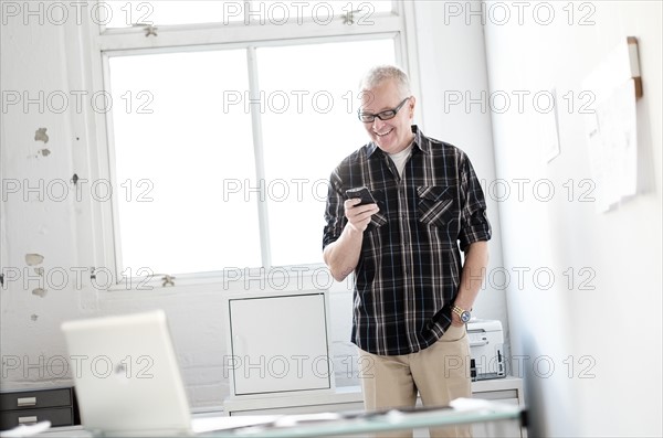 Man in office using smartphone.